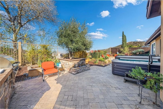 view of patio featuring an outdoor kitchen and a hot tub