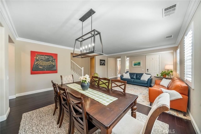 dining area featuring crown molding, a notable chandelier, and dark hardwood / wood-style flooring