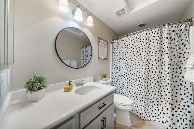 bathroom with a shower with curtain, vanity, tile patterned floors, and toilet