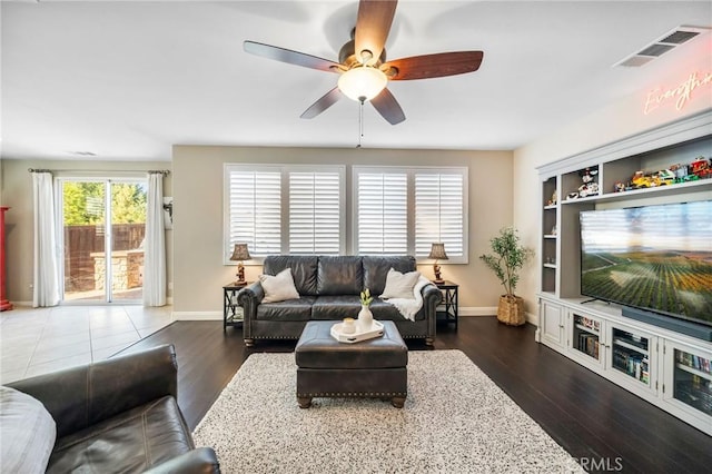 living room with dark wood-type flooring and ceiling fan