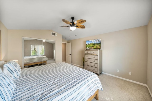 carpeted bedroom with ceiling fan, lofted ceiling, and a closet