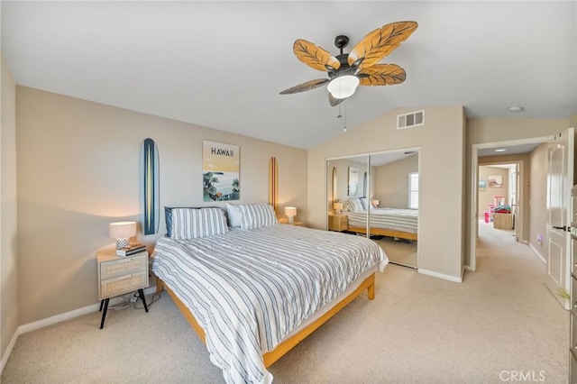 bedroom with ceiling fan, lofted ceiling, light carpet, and a closet