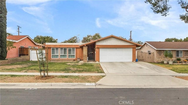 single story home with a front yard, a gate, fence, driveway, and a garage