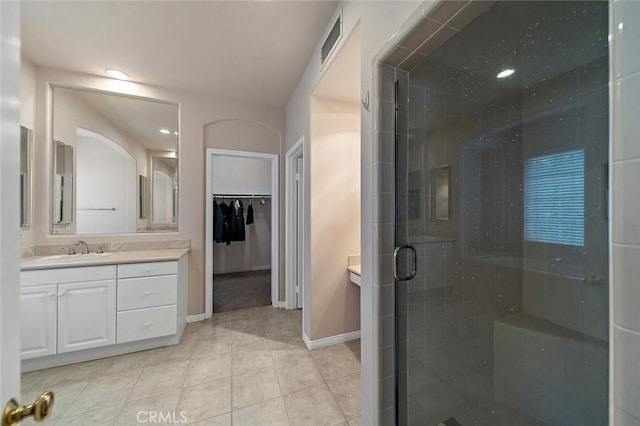 bathroom with tile patterned flooring, vanity, and a shower with shower door