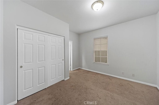 unfurnished bedroom featuring light colored carpet and a closet