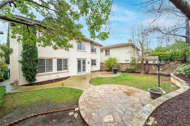 rear view of house with a patio and a lawn