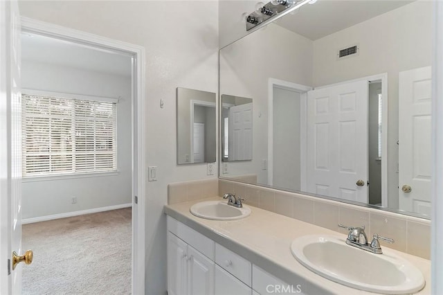 bathroom with tasteful backsplash and vanity