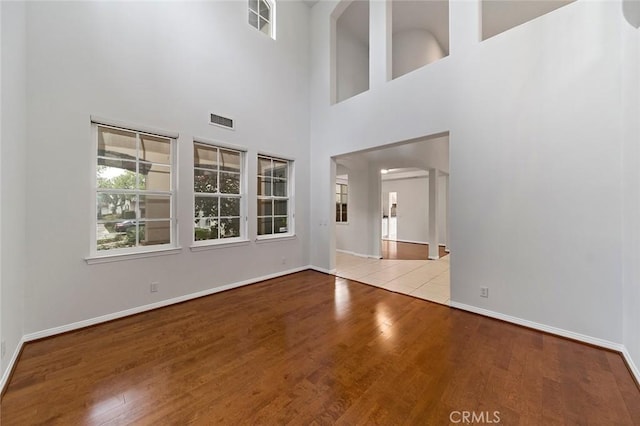 interior space with a towering ceiling and light hardwood / wood-style flooring