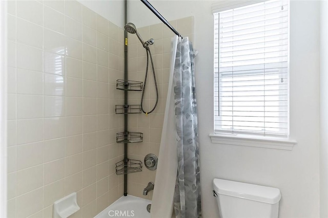 bathroom featuring toilet and shower / bath combo with shower curtain