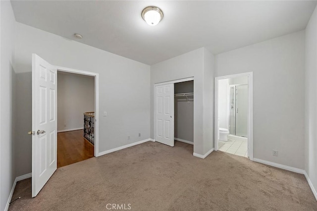 unfurnished bedroom featuring carpet flooring, connected bathroom, and a closet