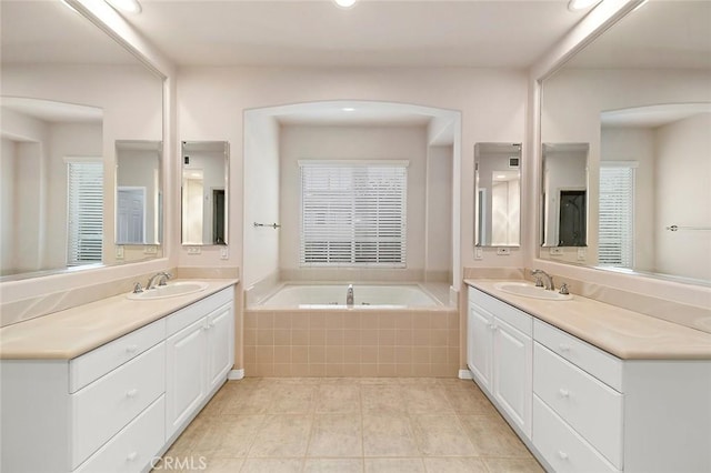 bathroom featuring vanity, tiled bath, and tile patterned flooring