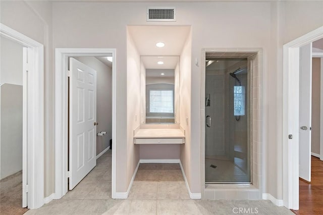 bathroom with tile patterned flooring and walk in shower