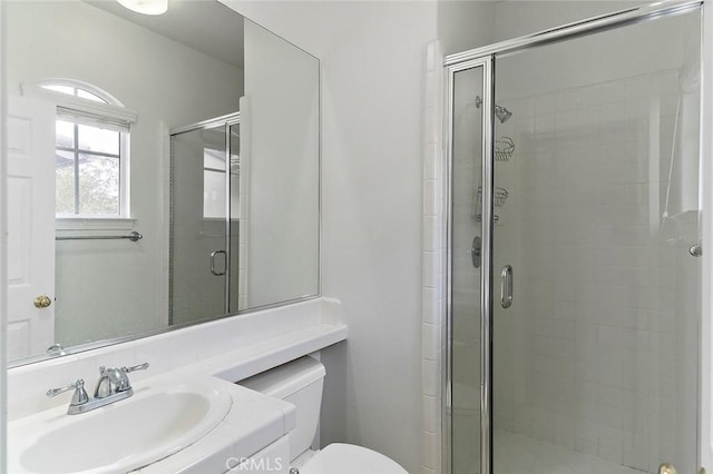 bathroom featuring vanity, an enclosed shower, and toilet