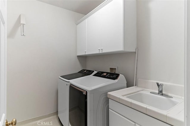 laundry area with sink, cabinets, and washing machine and clothes dryer