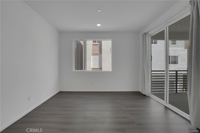 unfurnished room featuring a wealth of natural light and dark hardwood / wood-style floors