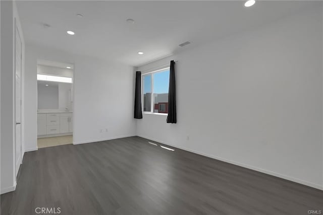 unfurnished room with dark wood-type flooring