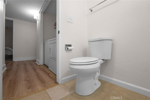 bathroom with toilet, tile patterned flooring, and baseboards