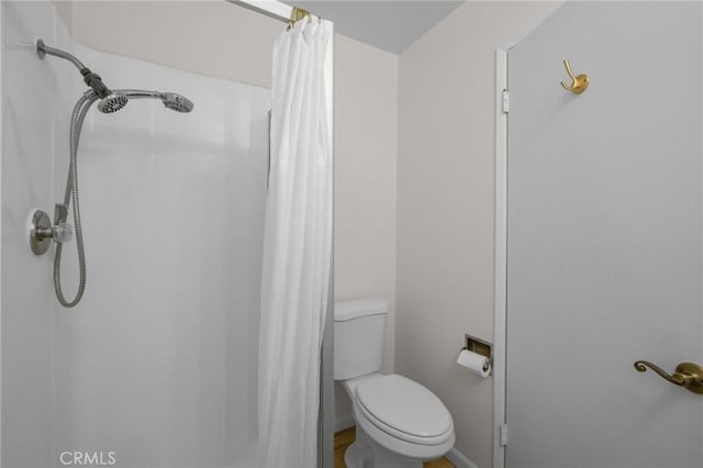 bathroom featuring a shower with curtain and toilet