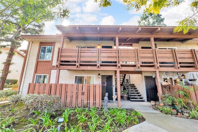 view of property featuring fence and stairway