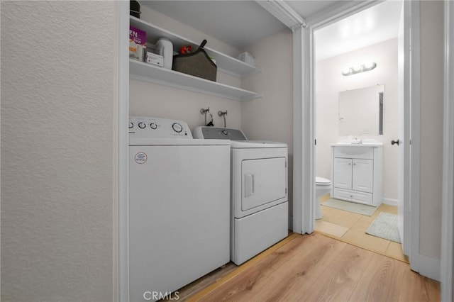 washroom with light wood-style floors, washer and dryer, and laundry area