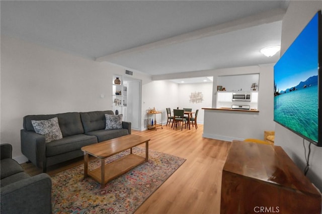 living area with visible vents, light wood-style flooring, and baseboards