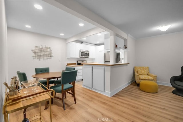 dining room featuring recessed lighting, baseboards, and light wood finished floors