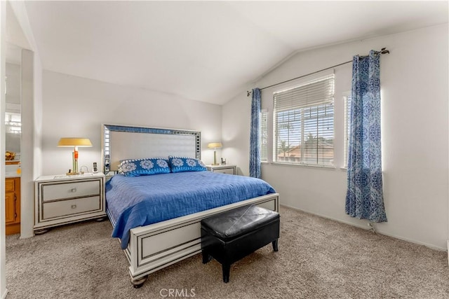 bedroom with vaulted ceiling and light colored carpet