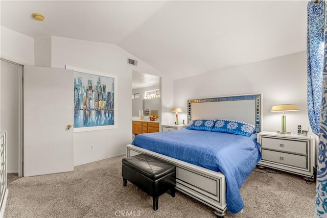 carpeted bedroom featuring vaulted ceiling and ensuite bath