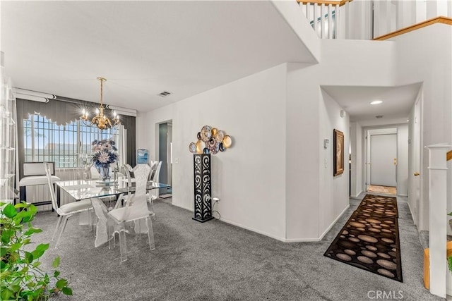 carpeted dining area with a chandelier