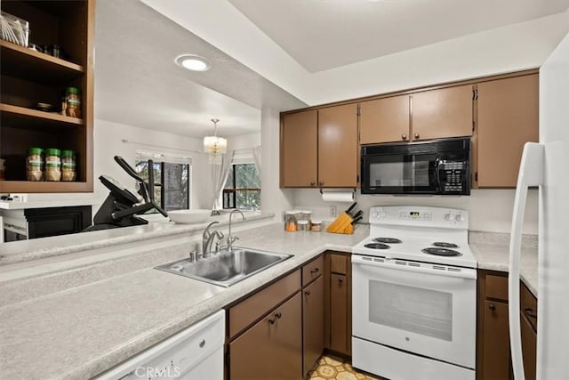 kitchen with an inviting chandelier, sink, white appliances, and hanging light fixtures