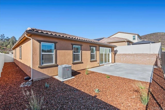 rear view of house with a patio and central AC unit