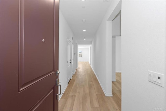 hallway with light hardwood / wood-style floors