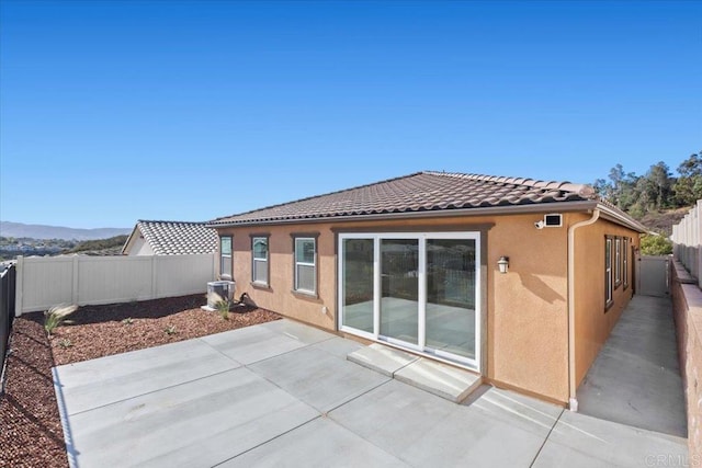 back of property featuring a mountain view and a patio area