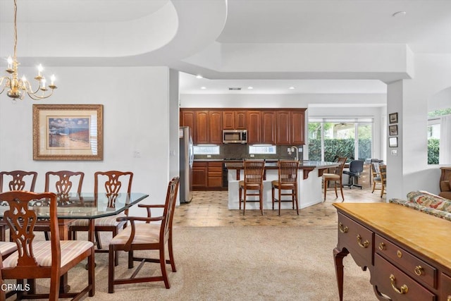 carpeted dining space with a chandelier