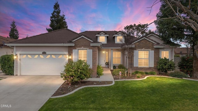 view of front of property with a garage and a lawn