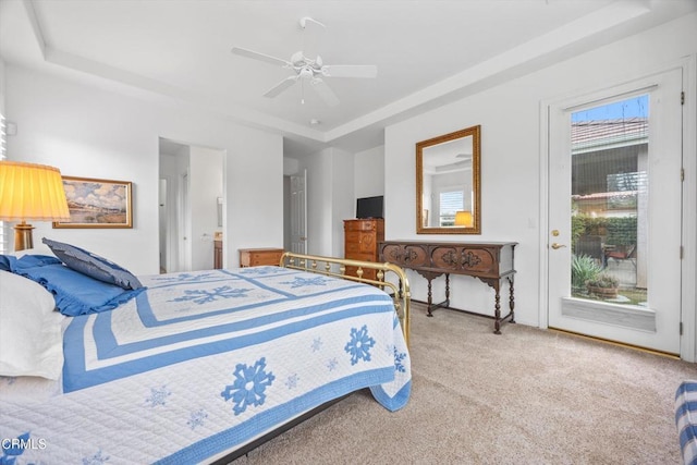 bedroom featuring carpet, access to outside, ceiling fan, and a tray ceiling