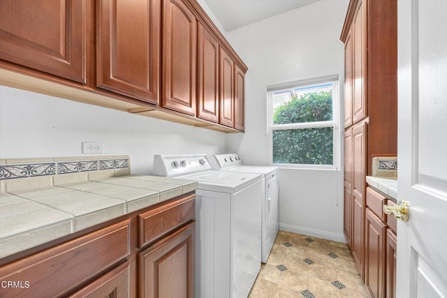 laundry room featuring cabinets and washing machine and clothes dryer