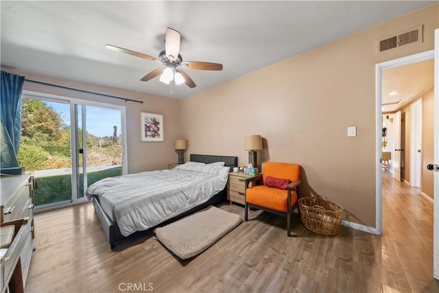 bedroom with access to exterior, wood-type flooring, and ceiling fan