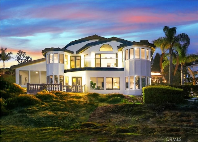 view of back house at dusk