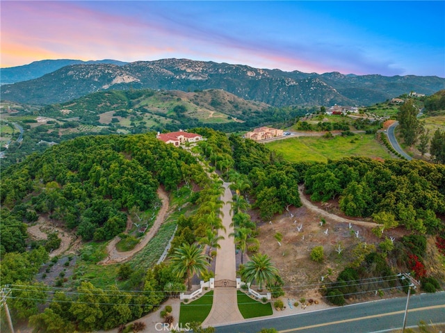 aerial view at dusk featuring a mountain view
