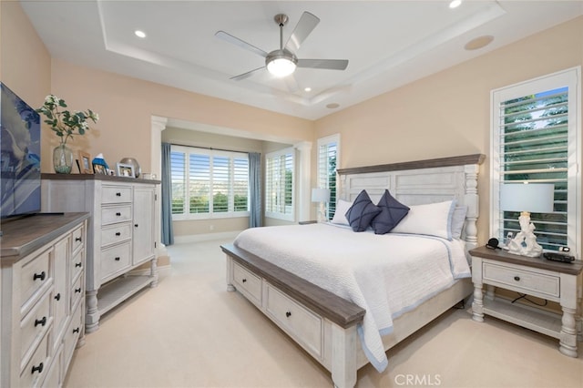 bedroom featuring light carpet, a tray ceiling, and recessed lighting
