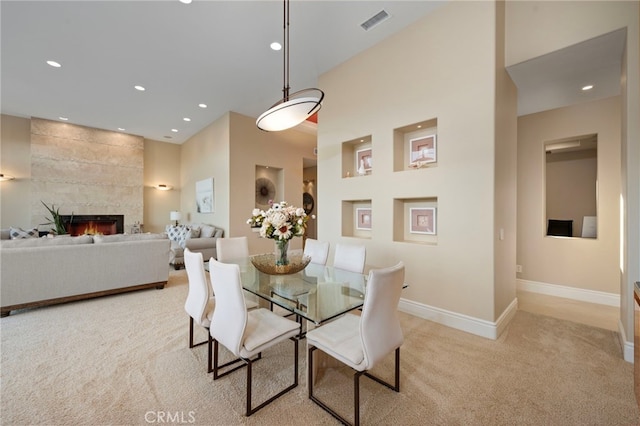 dining room featuring a fireplace, visible vents, recessed lighting, and light colored carpet