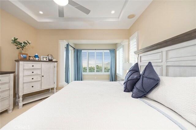 bedroom featuring recessed lighting, a raised ceiling, and a ceiling fan