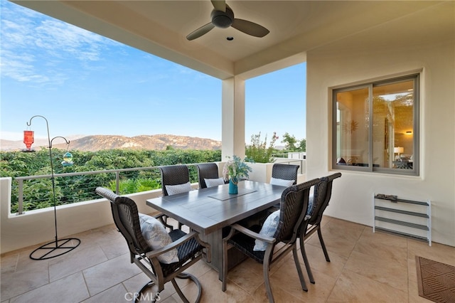view of patio featuring a ceiling fan, a balcony, and a mountain view