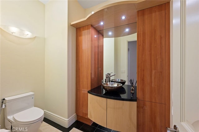 bathroom featuring tile patterned floors, toilet, baseboards, recessed lighting, and vanity