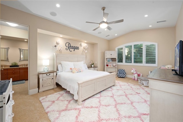 bedroom featuring lofted ceiling, visible vents, connected bathroom, baseboards, and light colored carpet