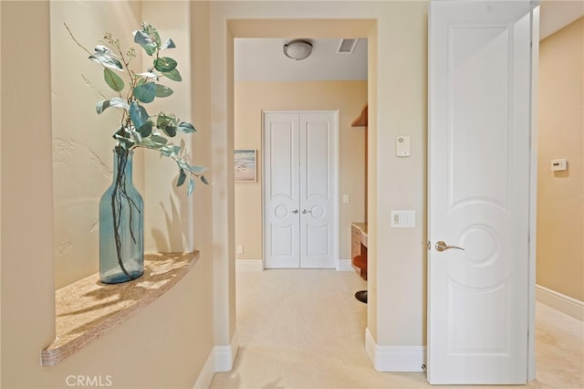 hallway featuring baseboards, carpet flooring, and visible vents
