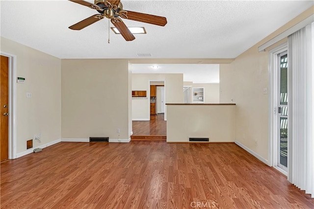 unfurnished living room with hardwood / wood-style floors, a textured ceiling, and ceiling fan