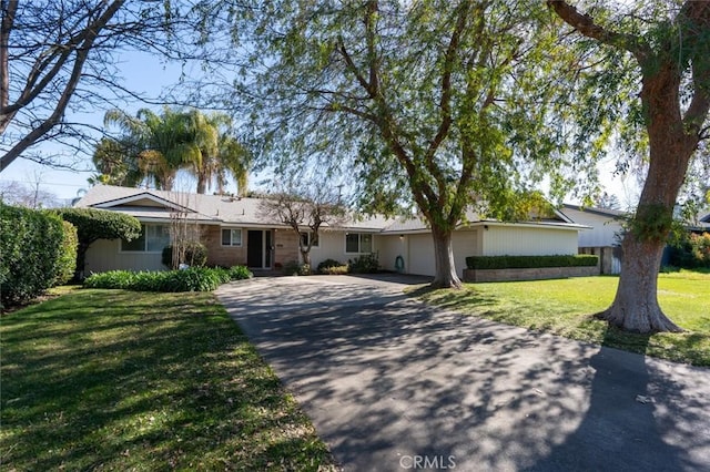 single story home featuring a garage and a front yard