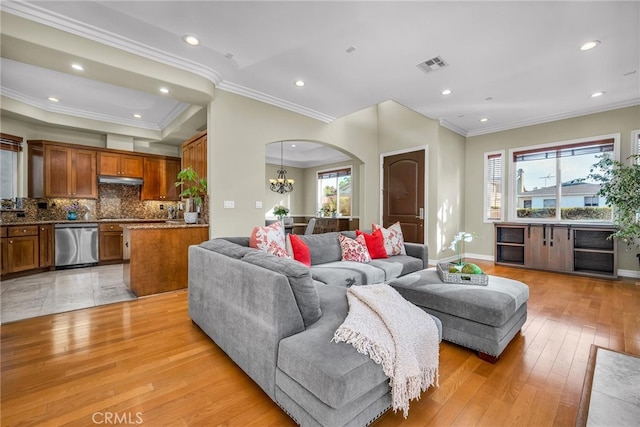 living room with ornamental molding, light hardwood / wood-style flooring, and a notable chandelier